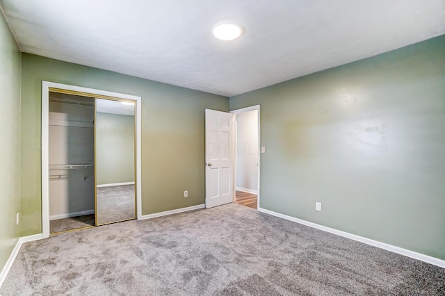 unfurnished bedroom featuring light carpet and a closet