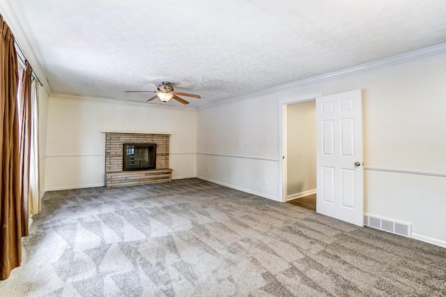 unfurnished living room with light carpet, a brick fireplace, ceiling fan, and crown molding