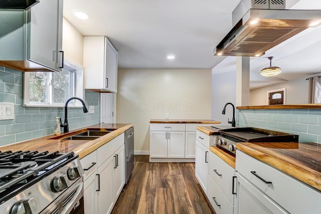 kitchen featuring wooden counters, stainless steel dishwasher, extractor fan, decorative light fixtures, and white cabinets