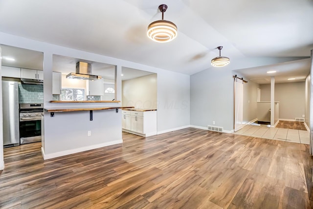 kitchen with wooden counters, range, tasteful backsplash, decorative light fixtures, and white cabinetry