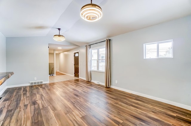 unfurnished living room featuring hardwood / wood-style flooring and lofted ceiling