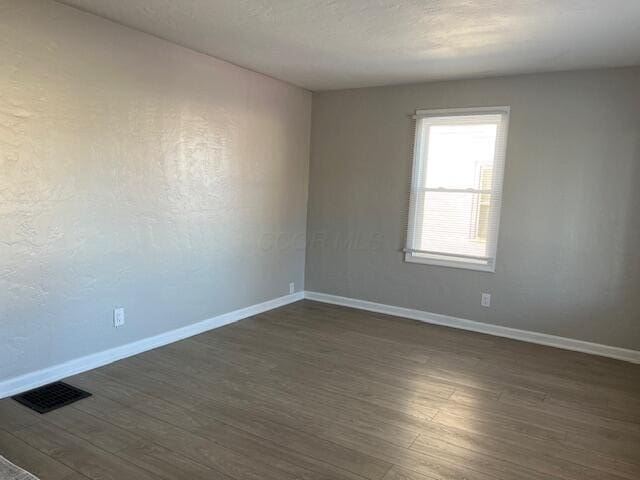 empty room with dark hardwood / wood-style floors