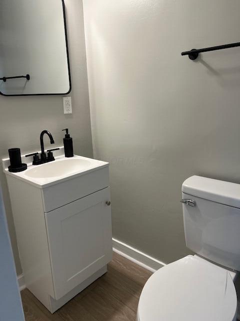 bathroom featuring vanity, hardwood / wood-style flooring, and toilet