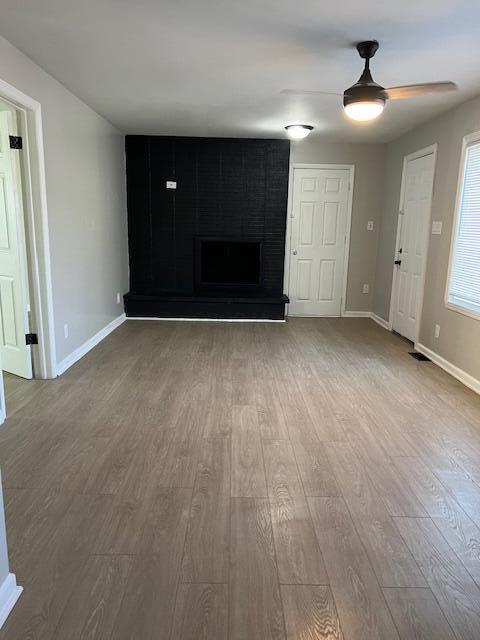 unfurnished living room featuring hardwood / wood-style flooring and a fireplace