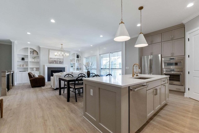 1474 Dogwood Loop, Powell, OH 43065 - kitchen featuring light wood-style floors, a kitchen island with sink, appliances with stainless steel finishes, and a sink