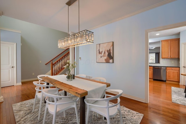 dining room with crown molding and light hardwood / wood-style floors