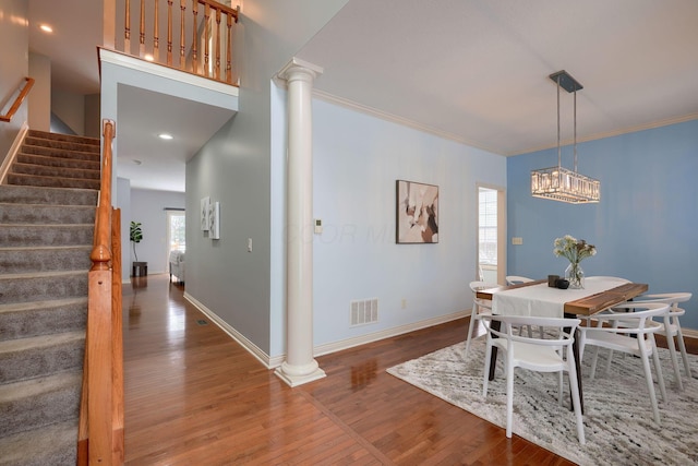 dining area featuring dark hardwood / wood-style floors, decorative columns, and ornamental molding