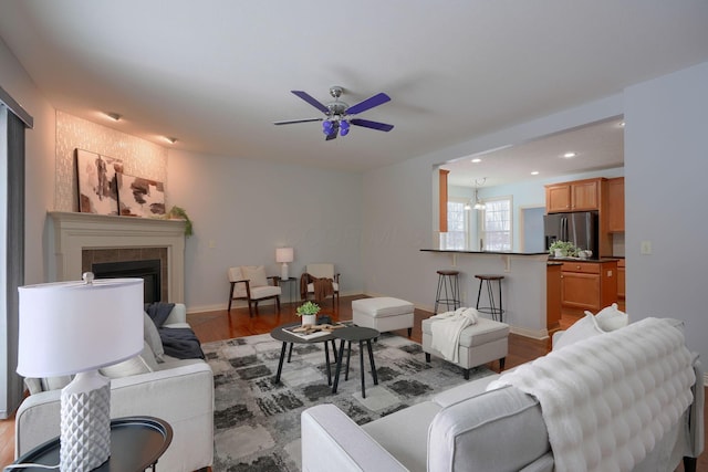 living room with hardwood / wood-style flooring and ceiling fan with notable chandelier