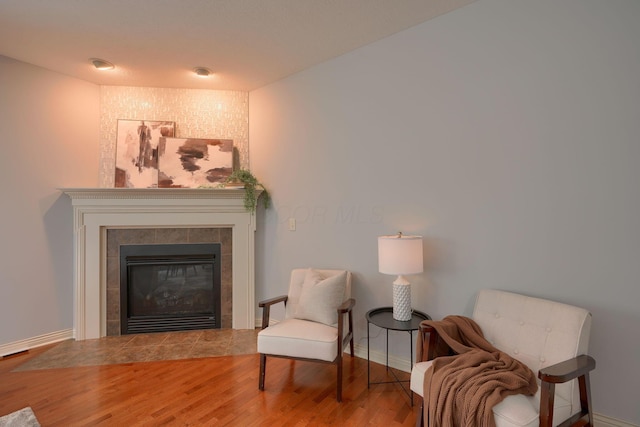 sitting room featuring hardwood / wood-style flooring and a tiled fireplace