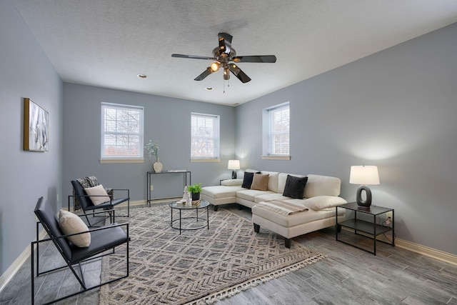 living room with ceiling fan, a textured ceiling, and hardwood / wood-style flooring