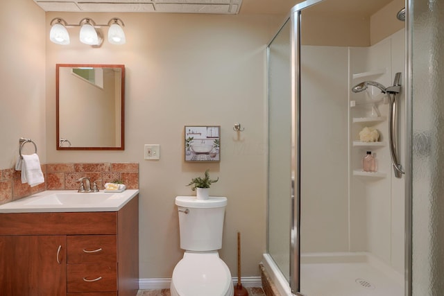 bathroom with vanity, tasteful backsplash, toilet, and a shower with door