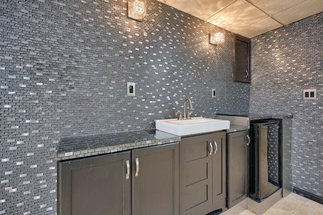 bathroom with tile patterned floors, vanity, wine cooler, and tile walls