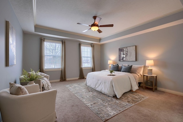 carpeted bedroom featuring a raised ceiling, ceiling fan, crown molding, and a textured ceiling