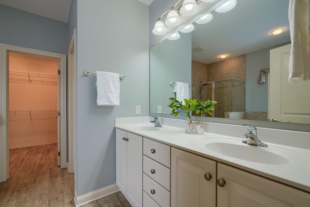 bathroom with hardwood / wood-style floors, vanity, and an enclosed shower