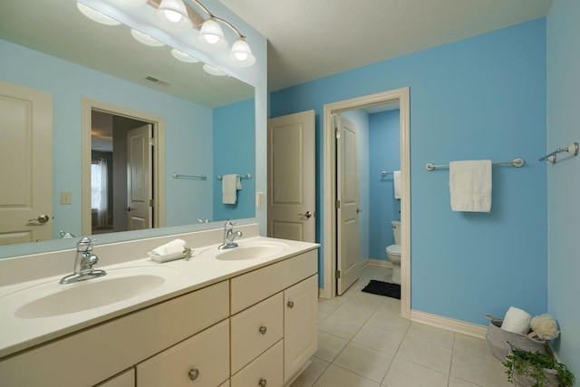 bathroom with tile patterned flooring, vanity, and toilet