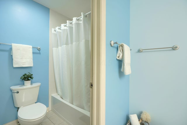 bathroom featuring tile patterned floors, toilet, and shower / tub combo with curtain