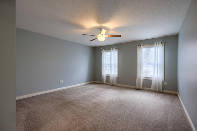 carpeted spare room with a textured ceiling and ceiling fan