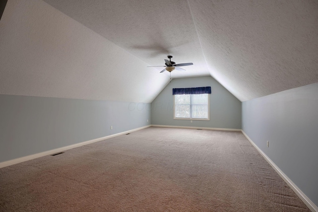 additional living space featuring carpet flooring, ceiling fan, a textured ceiling, and lofted ceiling