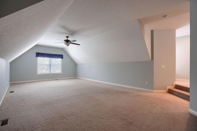 bonus room with carpet flooring, ceiling fan, a textured ceiling, and lofted ceiling