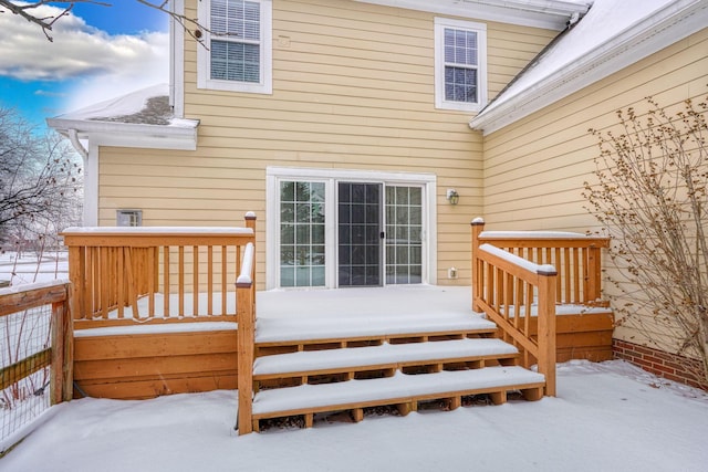 snow covered rear of property featuring a deck