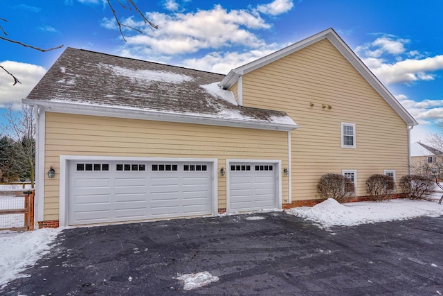 view of snow covered exterior featuring a garage