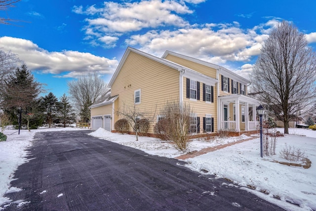 view of snowy exterior with a garage