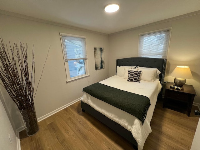 bedroom with crown molding and hardwood / wood-style flooring