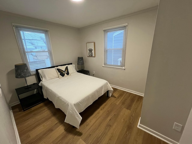 bedroom featuring hardwood / wood-style floors and crown molding