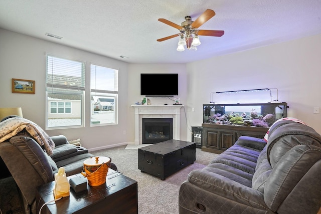 carpeted living room with ceiling fan and a textured ceiling