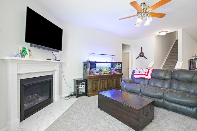 living room featuring ceiling fan and a fireplace