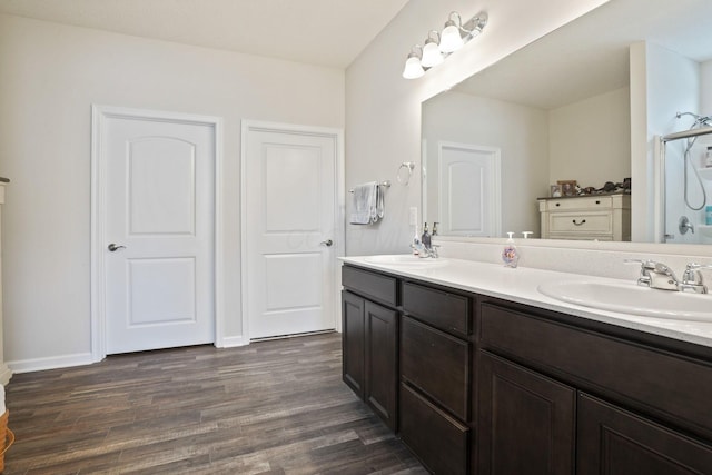 bathroom with a shower, hardwood / wood-style floors, and vanity