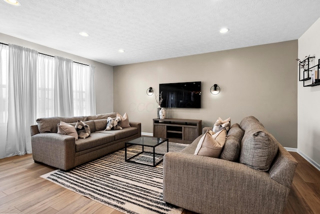 living room featuring a textured ceiling and light hardwood / wood-style flooring