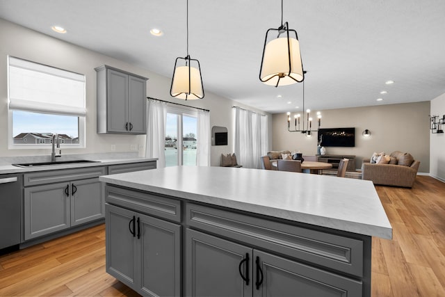 kitchen with a wealth of natural light, sink, pendant lighting, gray cabinets, and a kitchen island