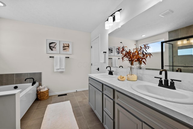 bathroom with tile patterned flooring, vanity, shower with separate bathtub, and a textured ceiling