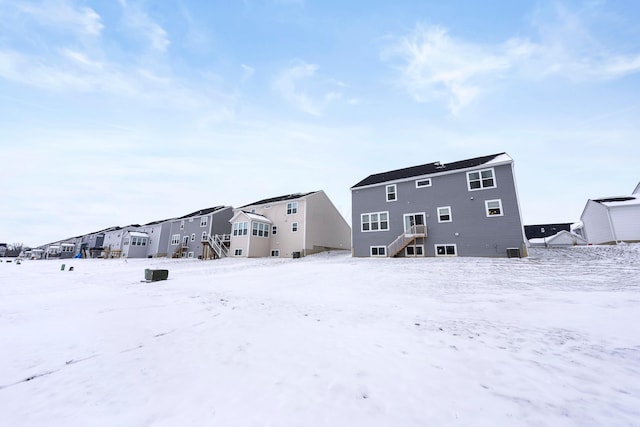 view of snow covered rear of property