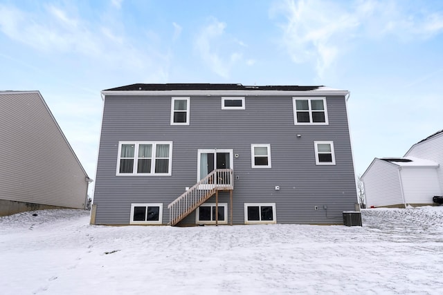 snow covered house with central AC unit