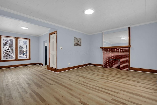 spare room featuring a fireplace, light hardwood / wood-style flooring, and ornamental molding