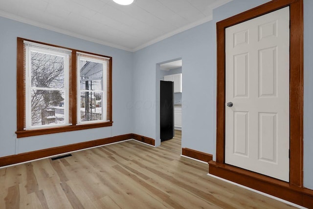 spare room with light hardwood / wood-style floors and ornamental molding