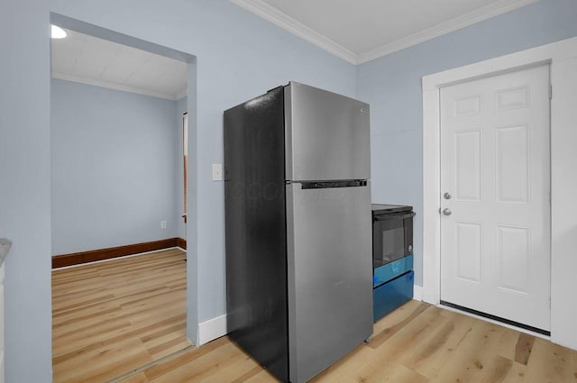 kitchen featuring stove, light hardwood / wood-style flooring, stainless steel refrigerator, and crown molding