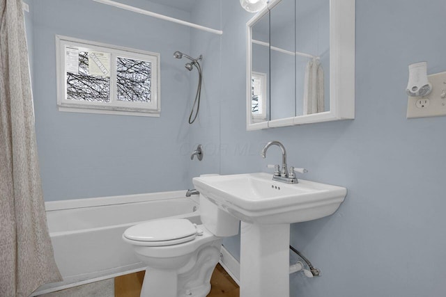 bathroom with hardwood / wood-style floors, toilet, and shower / tub combo with curtain