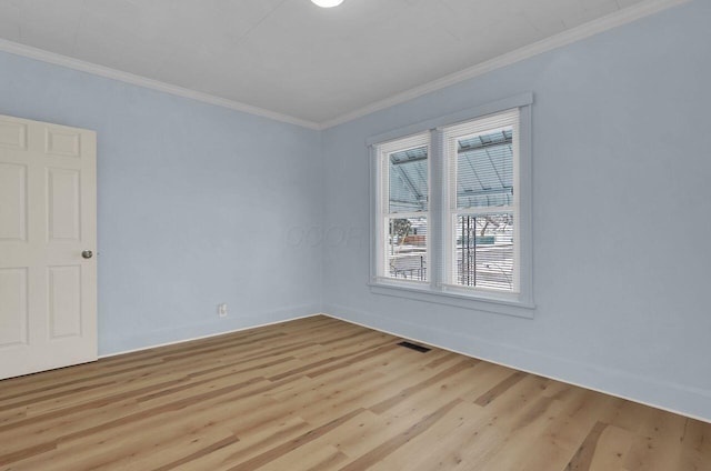 empty room with light hardwood / wood-style floors, crown molding, and a wealth of natural light