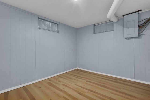 basement featuring electric panel and hardwood / wood-style floors