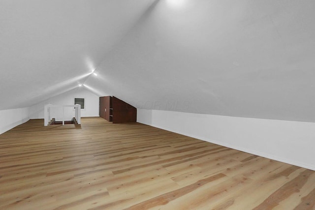 bonus room with vaulted ceiling and light hardwood / wood-style flooring