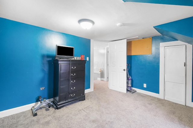 unfurnished bedroom featuring carpet and vaulted ceiling