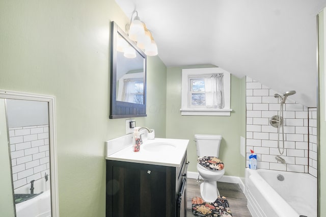 full bathroom with vanity, vaulted ceiling, hardwood / wood-style flooring, toilet, and tiled shower / bath