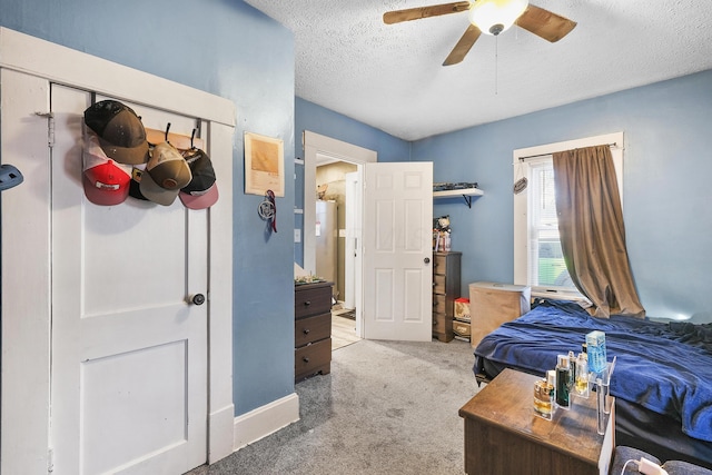 carpeted bedroom featuring ceiling fan and a textured ceiling