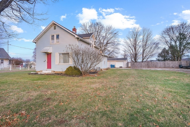 rear view of house with an outbuilding, a garage, and a lawn