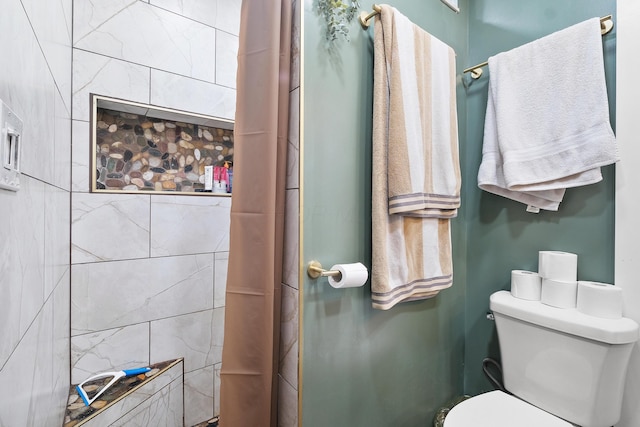 bathroom featuring a shower with shower curtain and toilet