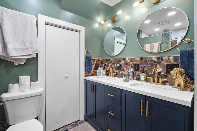 bathroom with backsplash, vanity, and toilet