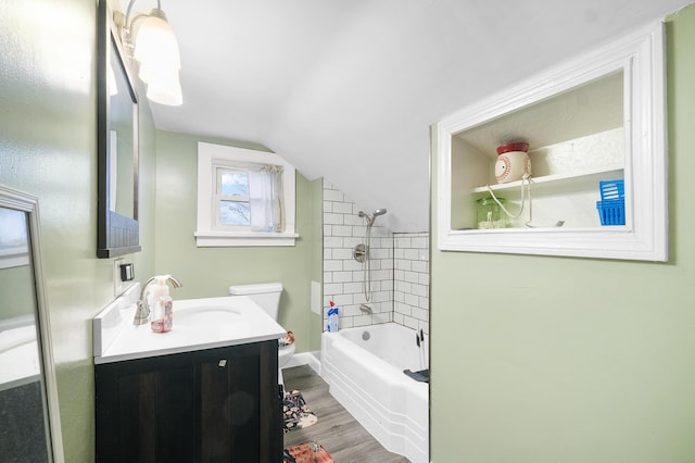 full bathroom featuring vanity, vaulted ceiling, hardwood / wood-style floors, toilet, and tiled shower / bath